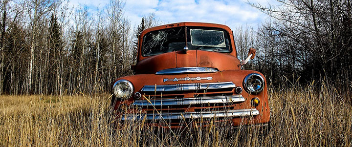 an old pickup truck in a field